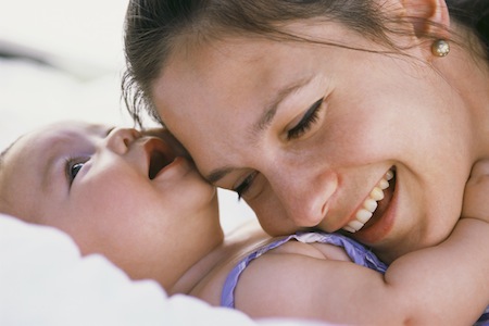 Mother Resting Head on Infant’s Chest