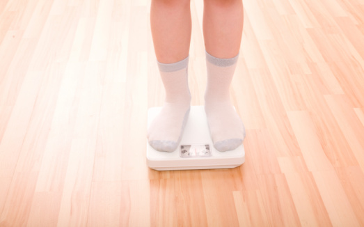 Boy measures weight on floor scales