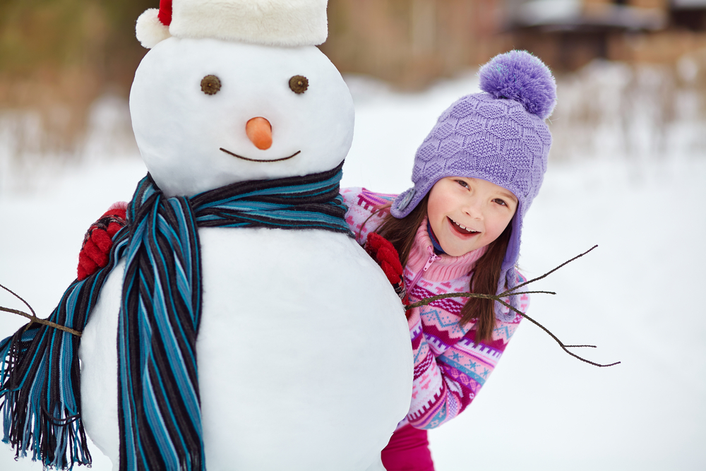 Bambina con pupazzo di neve