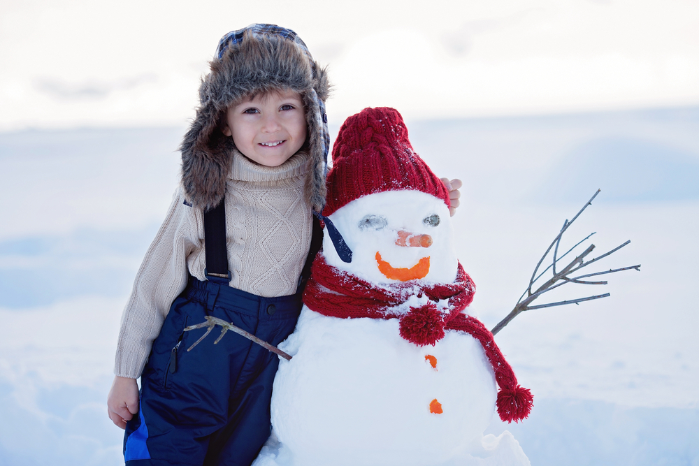 bimbo con pupazzo di neve