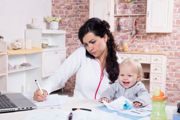 Mamma lavora con bimba in braccio