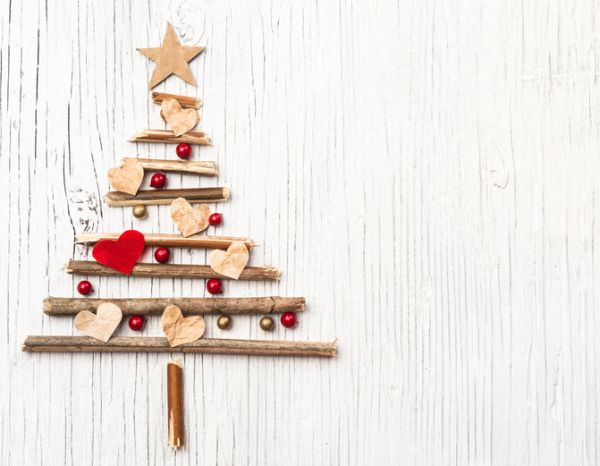 Christmas tree made of wooden branches on vintage wooden background with space for text